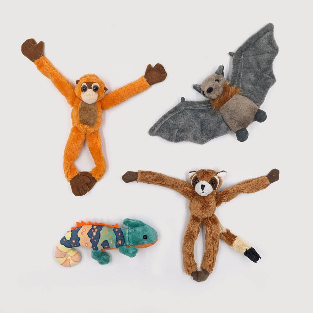 Four plush toys shaped like a monkey, bat, lizard, and fox on a white background