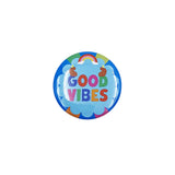 A round pin-back button badge featuring the words 'GOOD VIBES' in colorful block letters on a light blue cloud background, with a small rainbow and sun illustration above, shown on a plain white background.